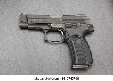 Pistol on the office desk. The concept of blackmail, threats, murder for enrichment