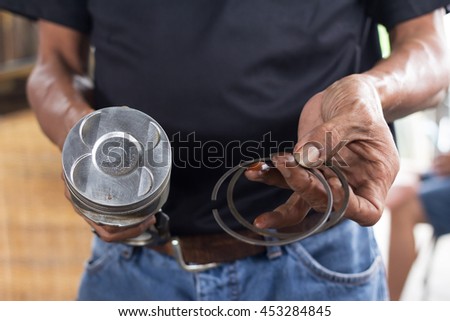 Piston and cylinder ring in car mechanic hands 