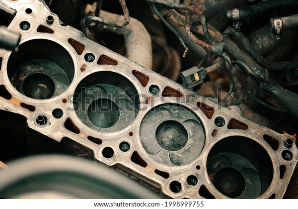 Pistons\
and cylinder head of engine block vehicle. Motor capital repair.\
Sixteen valve and four cylinder. Car service concept. The job of a\
mechanic. Old and new pistons. High quality\
photo