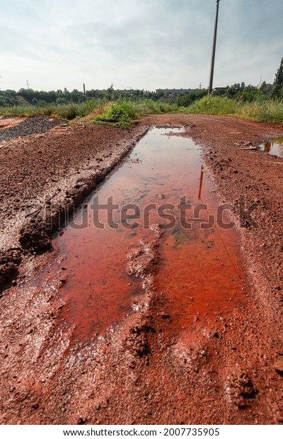 Pit with a puddle\
in red mud from iron ore.