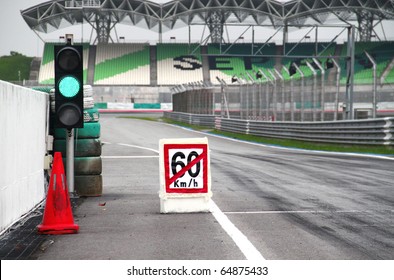 Pit stop exit with speed limit signboard and traffic light. Concept of safety measures for motor sport participants.