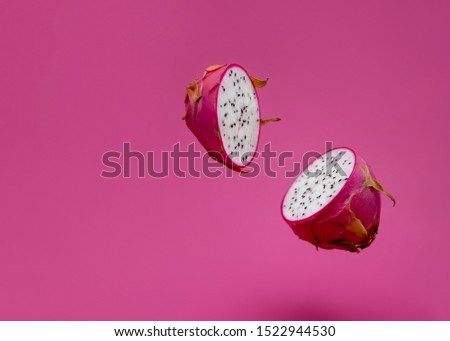 Pitaya or dragon fruit levitate on pink background.
