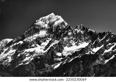 Pitch black-white dramatic view of top part ot Mt Cook peak the tallest mountain of New Zealand under dark sky.