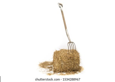 A Pitch Fork Stuck Into A Bale Of Straw