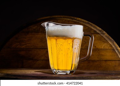 Pitcher of beer on wooden background