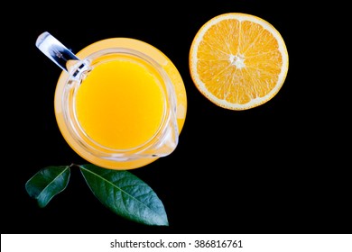 pitcher of fresh orange juice on black background top view