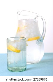 Pitcher And Glass Of Ice Water With Lemon Wedges