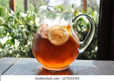 Pitcher Of Iced Sweet Tea With Sliced Lemon And Ice On A Porch