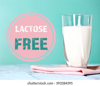 Pitcher Of Milk On Wooden Table And Lactose Free Sign On Blue Background