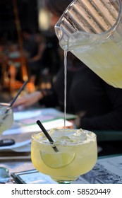 Pitcher Pouring Liquid Into Margarita Glass.