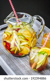 A Pitcher Of White Peach Sangria With Two Glasses