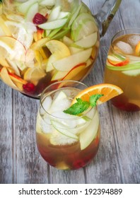 A Pitcher Of White Peach Sangria With Two Glasses