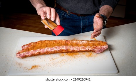 Pitmaster Prepares Baby Back Ribs For Smoking By Applying Rub