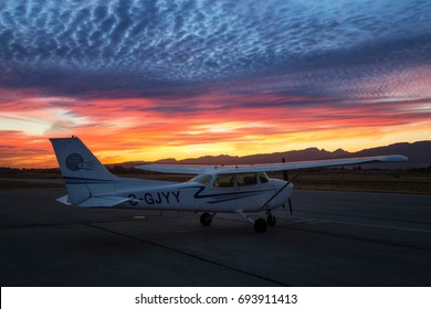 Pitt Meadows, Greater Vancouver, British Columbia, Canada - July 26, 2017 - Small airplane, Cessna 172, parked at the airport during a beautiful and colorful sunset.