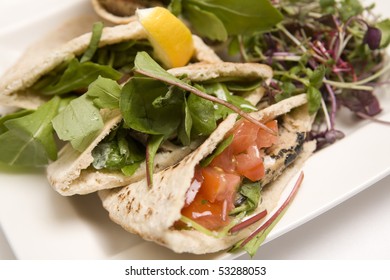 Pitta Bread Filled With A Tuna Salad On A White Plate.