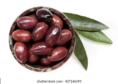 Pitted Black Kalamata Olives In Small Bowl With Leaves, Isolated.  Top View.