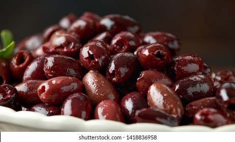 Pitted kalamata olives in bowl on rustic wooden background - Powered by Shutterstock