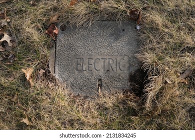 Pittsburgh, PA USA. March 2, 2022. Cement block with the word electric  engraved on top is seen in dried grass and dead leaves on a sunny winter day in the Pittsburgh area.