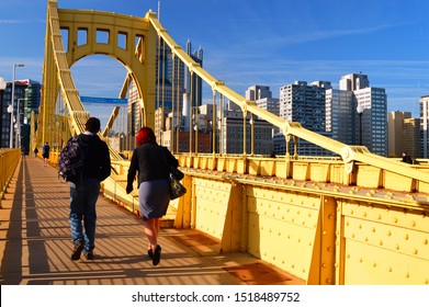 Pittsburgh, PA, USA May 6 A Couple Walks Across The Roberto Clemente Bridge, Heading Towards Downtown Pittsburgh, Pennsylvania