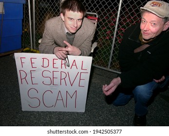 Pittsburgh, PA USA. October 22, 2011. Two Men, One Older And One Younger Looking Up At The Camera While Holding A Sign About The Federal Reserve Being A Scam.