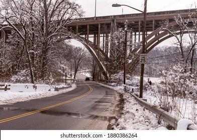 Pittsburgh, Pennsylvania, USA 12-19-20 Commercial Street under the State Route 376 parkway bridge on a winter day with the street wet from being salted as it runs through Frick Park