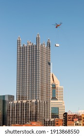 Pittsburgh, Pennsylvania, USA 2-6-21 A sky crane helicopter delivering a air conditioning unit to the top of the PPG building in downtown Pittsburgh on a sunny winter day