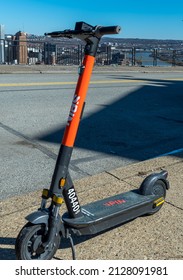 Pittsburgh, Pennsylvania, USA February 20, 2022 An electric scooter, E-Scooter, rentable from the city of Pittsburgh is seen parked on the sidewalk in Mt Washington overlooking downtown 