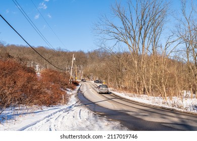Pittsburgh, Pennsylvania, USA January 29, 2022 Cars driving along Commercial Street through Frick Park on a sunny winter day