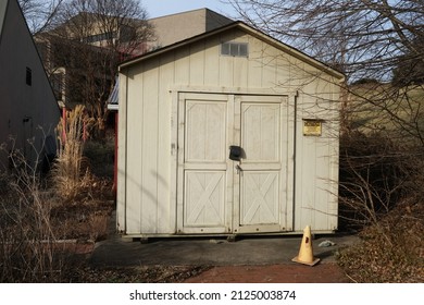 Pittsburgh,PA USA. February 16, 2022. Yellow shed with a road cone seen in an open wooded area on a winter day in the West Mifflin neighborhood of Pittsburgh.
