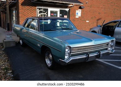 Pittsburgh,PA USA. January 5, 2022. Blue Plymouth Fury 3 car seen parked in front of a business next to car with an open door on a sunny day on Liberty Avenue in Pittsburgh.