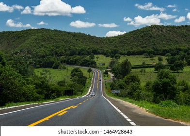 PIUMHI, MINAS GERAIS / BRAZIL - NOVEMBER 16, 2017: View of the mountainous green landscape under clouded blue sky at KM 277 of MG-050 "Newton Penido" highway heading to Betim, inside Piumhi region.