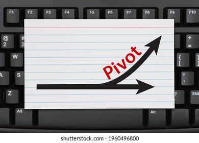 Pivot message with arrow an index card on a black keyboard 