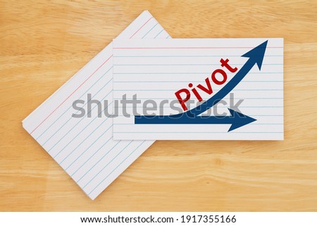 Pivot message with arrows on white paper index cards on wood desk