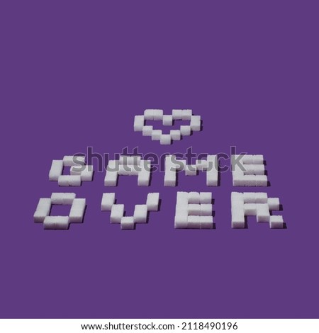 Pixel sign "Game over" and heart made from sugar cubes on purple background. Minimal Vaporware creative love or Valentines concept.