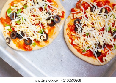 Pizza before Baking, A close view of raw pizza, with tomato, mozzarella cheese dices, before being cooked in an oven, typical of Italian cuisine - Image