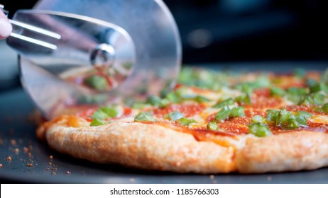 Pizza Being Cut By Pizza Cutter. Close Up Of Crust And Pizza