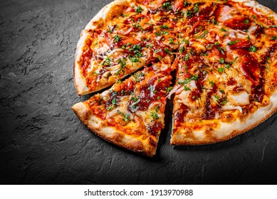 Pizza mit Huhn und Grillsoße. Italienische Pizza auf dunkelgrauem schwarzem Hintergrund
