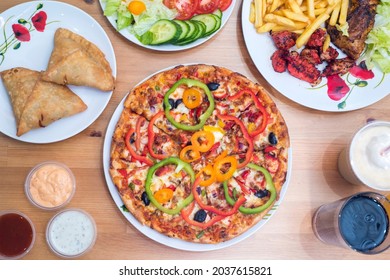 Pizza, Chips, Salads, Samosas, Chicken Tikka And Grilled Chicken With Drinks And Dips, From Above