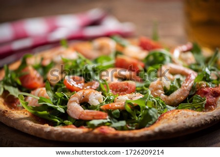 Pizza covered with roquette and shrimps close up [[stock_photo]] © 