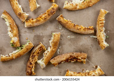 Pizza Crusts In A Greasy Box On A Home Table. Leftover Pieces Of Pizza. Bread Crumbs, Grease Stains And Specks. Top View, Close-up. High-calorie Food