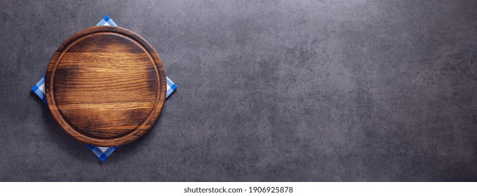 Pizza cutting board and cloth napkin on stone surface of table. Food recipe concept at tabletop or wall background texture with copy space. Flat lay of  panorama, panoramic top view - Shutterstock ID 1906925878
