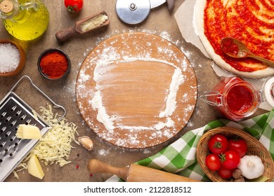 Pizza cutting board and flour homemade cooking or baking on table. Pizza ingredient at tabletop background top view. Recipe concept in kitchen - Powered by Shutterstock