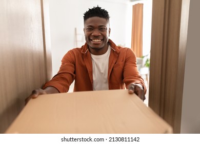 Pizza Delivery. Cheerful African American Guy Holding Cardboard Box Receiving Order From Pizzeria Standing In Opened Door At Home, Smiling To Camera. Selective Focus