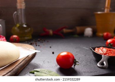 Pizza And Dough Homemade Cooking With Ingredients At Table. Pizza With Sauce On Tabletop Background. Recipe Concept In Kitchen