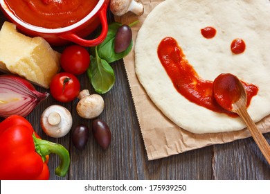 Pizza dough with tomato sauce smile and parmesan cheese, fresh tomatoes, basil, red onion, olives and mushrooms on a wooden background. - Powered by Shutterstock