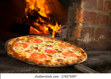 Pizza entering a wood oven