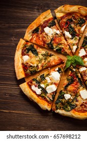 Pizza With Feta Cheese And Spinach On Wooden Table