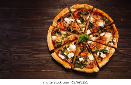 Pizza With Feta Cheese And Spinach On Wooden Table