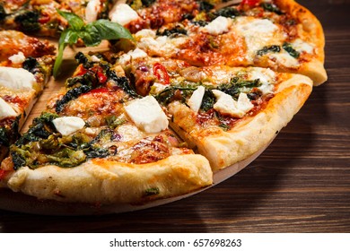 Pizza With Feta Cheese And Spinach On Wooden Table