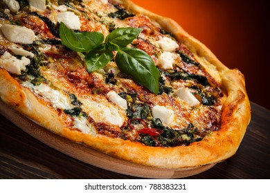 Pizza With Feta Cheese And Spinach On Wooden Table